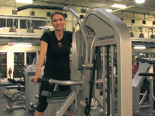 Cathe on a Nautilus Gravitron (assisted pull up machine)