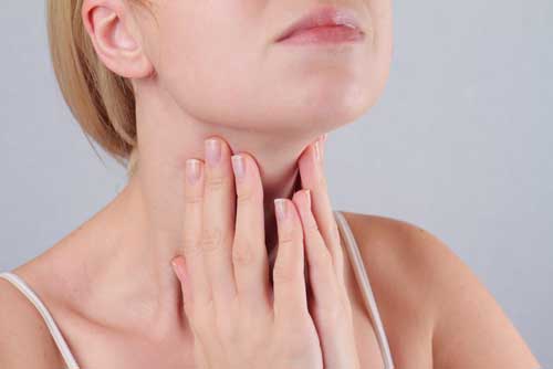 A woman checking her thyroid gland