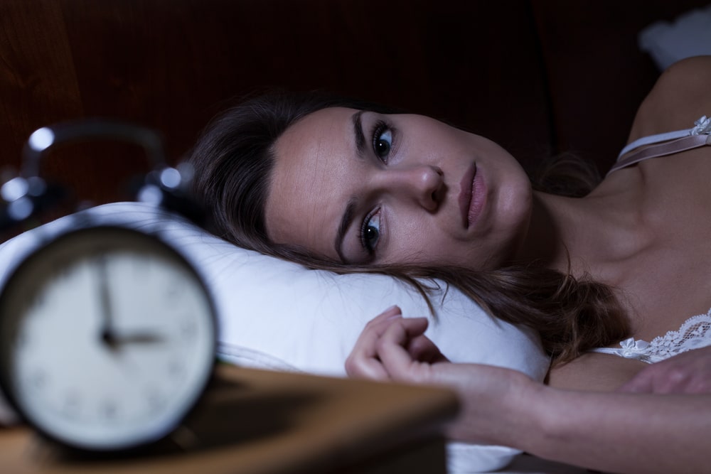 A woman in bed can't fall asleep. Is it normal to have sleep problems as you get older?