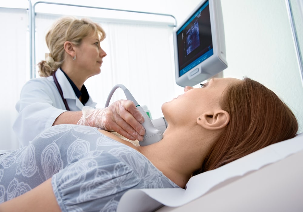 A Doctor checking a patient for thyroid cancer. 