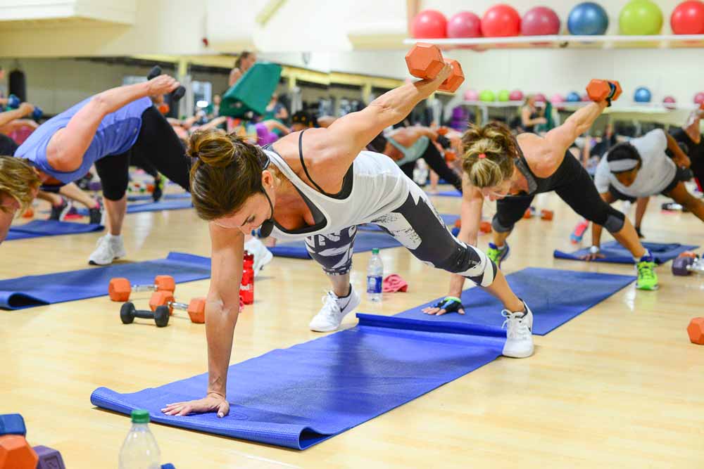 image of Cathe and several Cathletes doing a plank kickback and working on greater muscle endurance during the 2017 Glassboro road trip