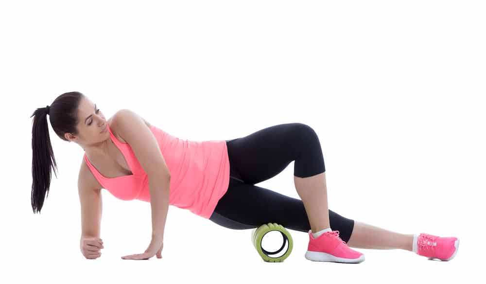 image of female exerciser trying to improve the appearance of cellulite in her thighs by using a foam roller