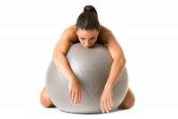 image of tired female exerciser resting on a stability ball after training too hard