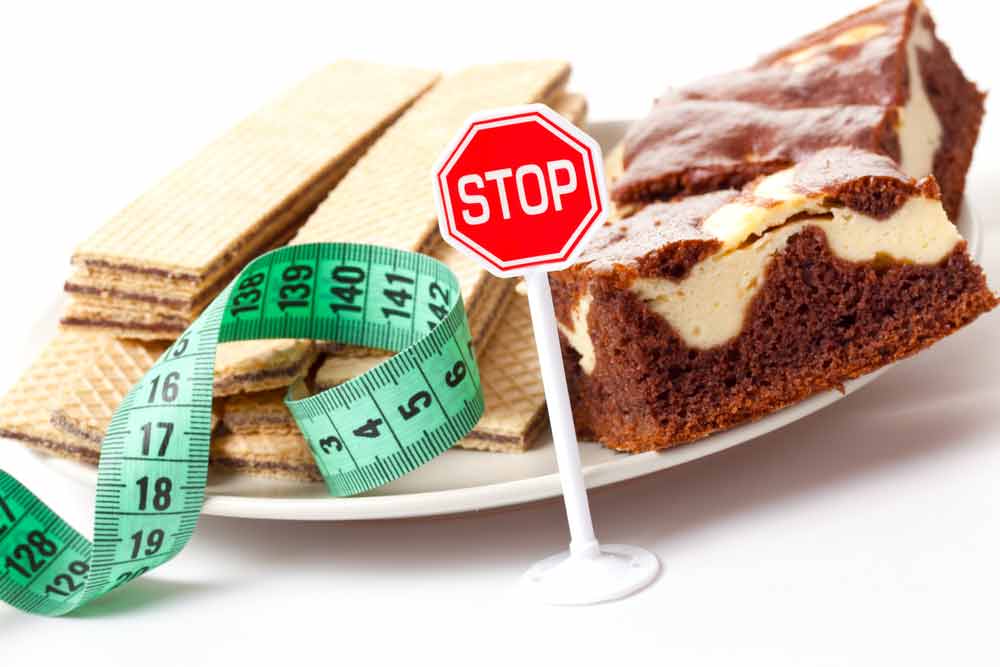 image of desert foods high in sugar and a stop sign suggesting you learn to stop your sugar cravings