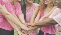 image of several women in pink joininh hands to fight cancer