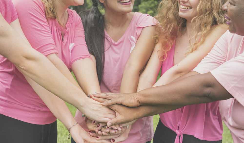 image of several women in pink join hands to fight various cancers
