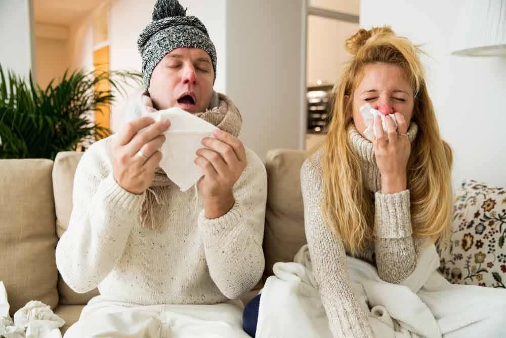 Image of a woman and man with a bad cold. Does cold weather increase your risk of catching a cold?