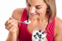 image of woman eating yogurt with probiotics