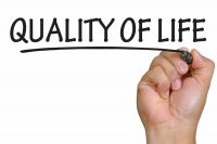 image of a hand writing the words Quality of Life