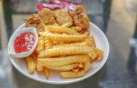 image showing unhealthy processed foods on a plate with fries, chicken nuggets and ketchup
