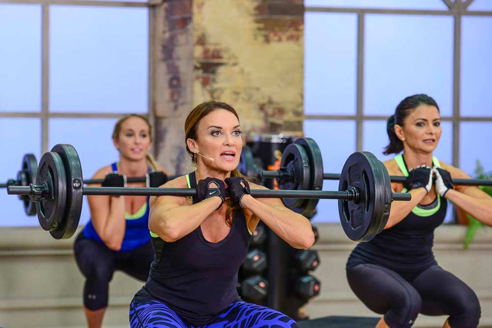 image of cathe Friedrich,Nicole and Jai during Fit Split Push Day doing a front squat and toning muscles