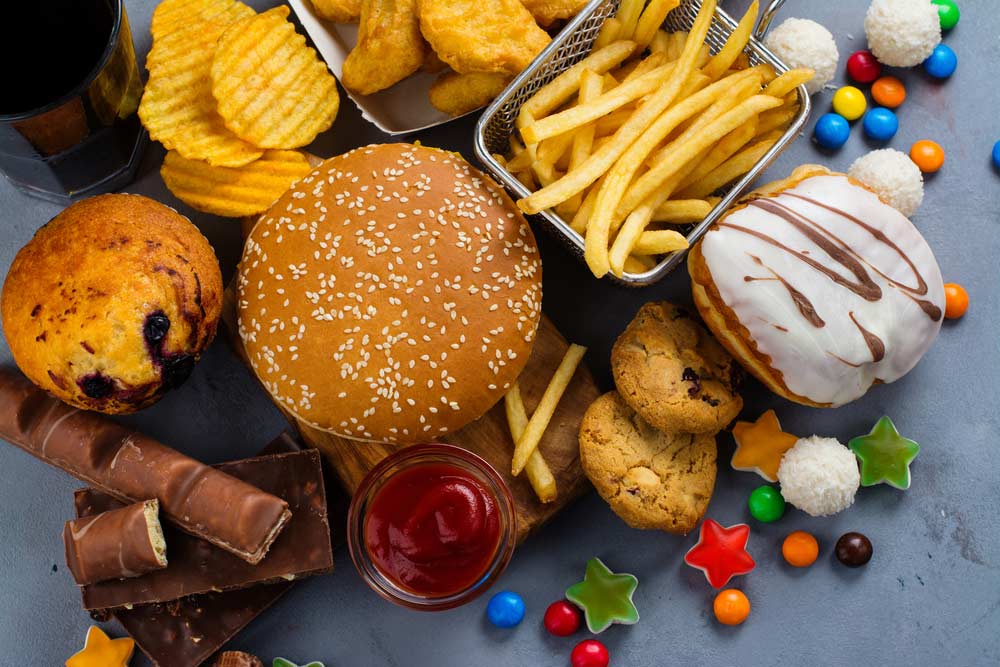 image of unhealthy fast food, sweets and salty snacks that cause cravings