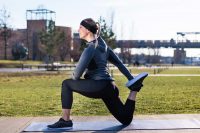 image of a woman doing a quadriceps stretch outside