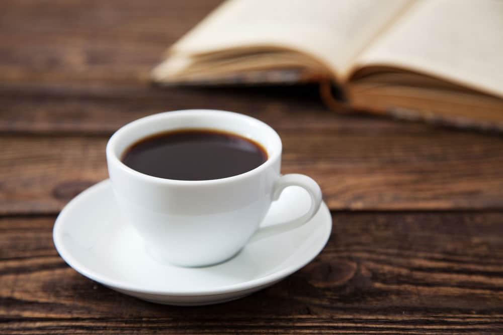 image of a Cup of coffee on a wooden table. Can drinking coffee boost your metabolism?