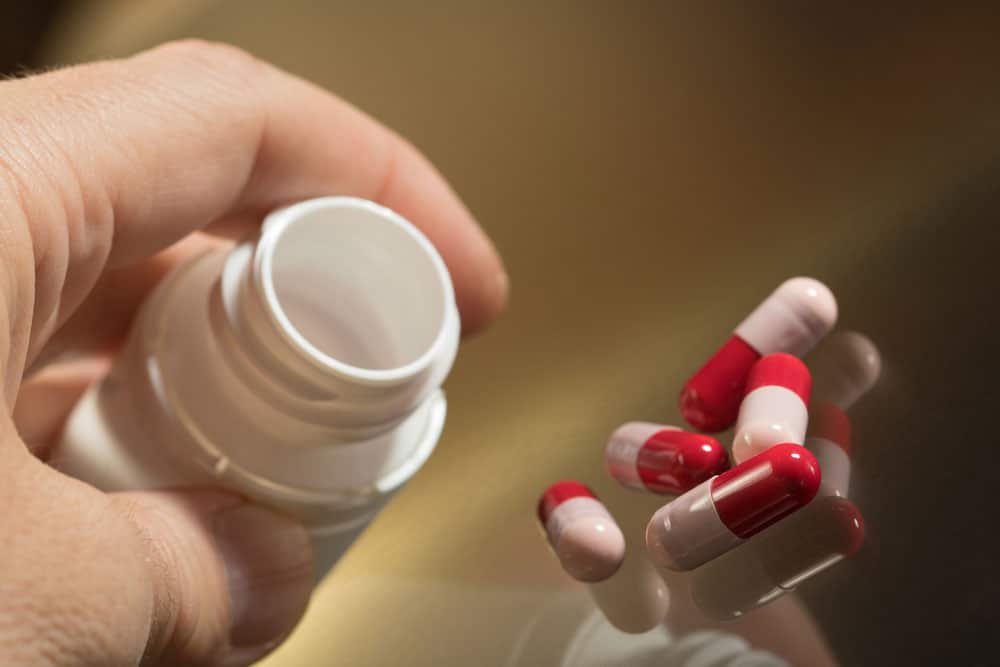 mage close up of Probiotic Supplements capsule bottle between the fingers