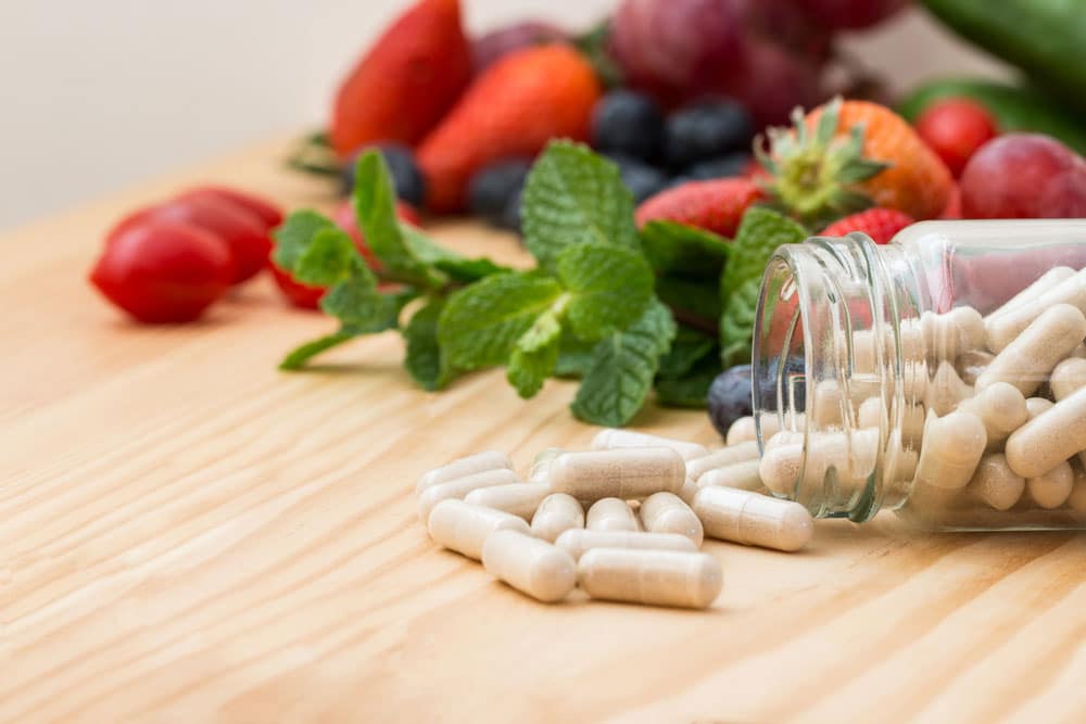 image of vitamins in bottle on wooden table.