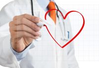 image of a male doctor drawing heart symbol at interactive whiteboard