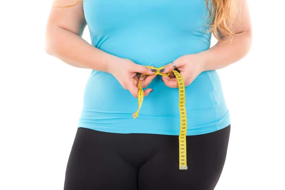 image of a woman measuring her waist 