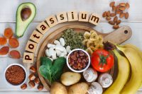 image of Potassium Food Sources as dried apricots, raisins, avocado, cocoa, bean, pumpkin seeds, dried banana, potatoes, tomatoes, spinach, mushrooms, fresh banana, hazelnuts, almonds.