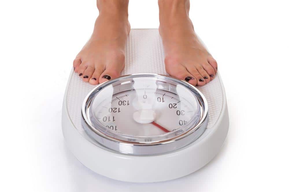 A woman standing on weighing scale.