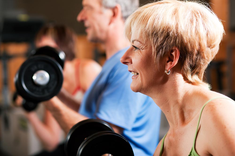 Senior exercise lifting weights which helps improve their quality of life and reduce the risk of dying prematurely. 