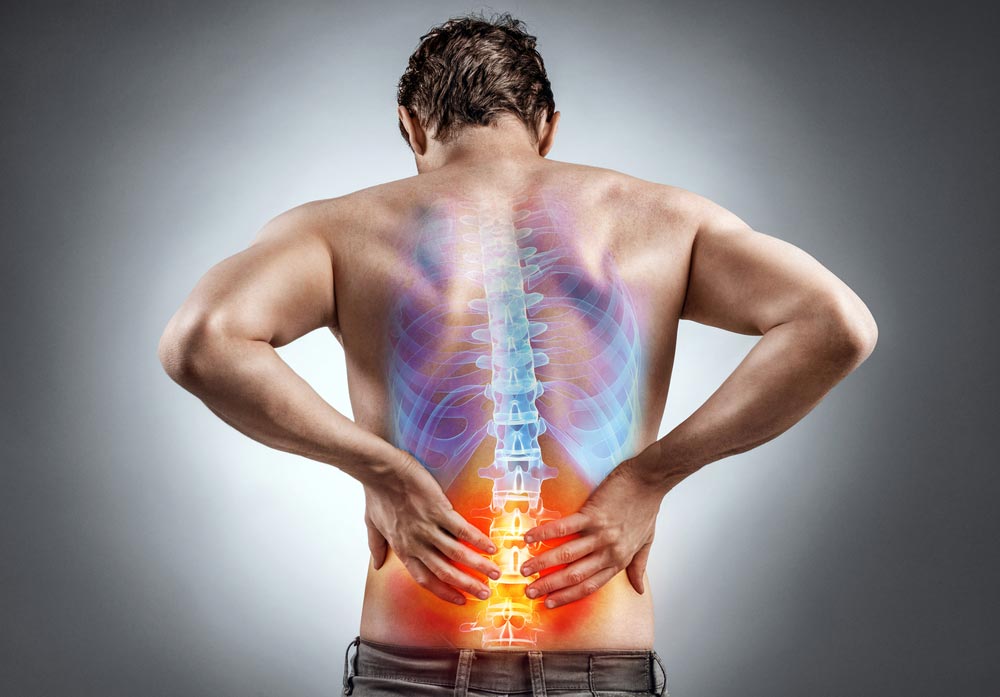 Back view of a male having lower back pain cause by spine alignment problems