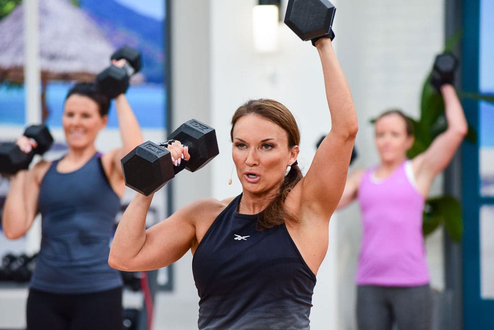 Cathe Friedrich doing a dumbbell overhead press