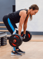 Cathe Friedrich using barbell deadlifts in her Total Body Barbell workout for Glute strengthening