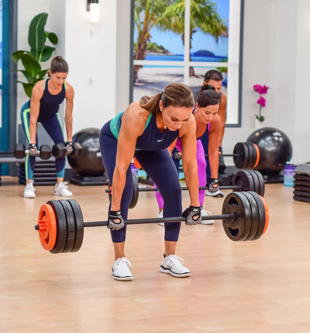 Cathe Friedrich doing a deadlift and also working her transverse abdominis muscle